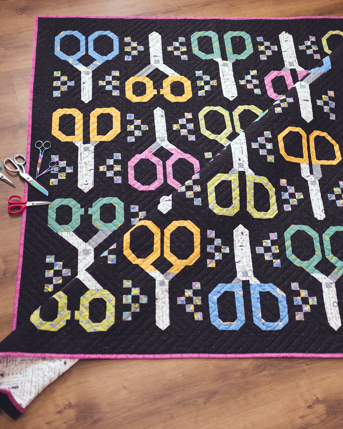 Quilt with scissors pattern on a wooden surface